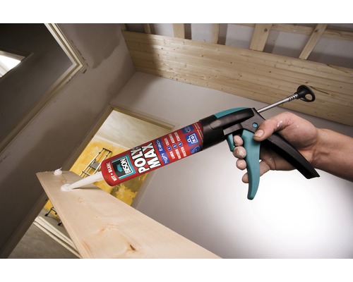 Mână ține pistolul de cartuș cu adeziv de construcție pentru prelucrarea lemnului