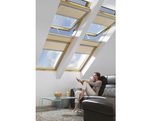 Camera de zi cu ferestre de mansardă și jaluzele opace, o femeie stă pe canapea