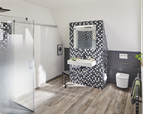 Baie modernă cu duș, lavoar, oglindă și toaletă sub un acoperiș înclinat