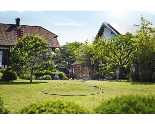 Gazon udat cu aspersor de gazon într-o grădină.