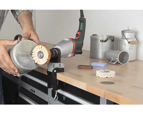 Mașină de lustruit cu piesă de lucru și accesorii pe un banc de lucru