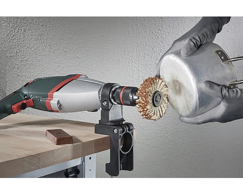 Unealtă electrică cu o perie montată, prelucrând o oală.