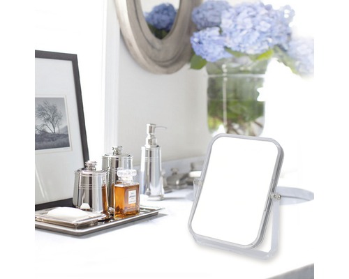 Scenă de baie cu oglindă cosmetică, dozator de săpun și obiecte decorative pe o suprafață albă