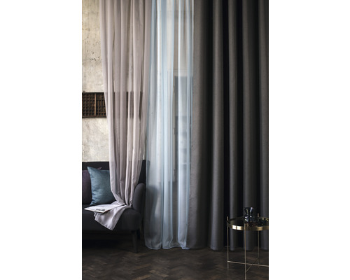 Fotografie de interior a unui living cu perdele, canapea și măsuță laterală.