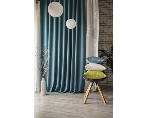 Cameră de zi decorativă cu perdele, lămpi de hârtie și perne pe un scaun