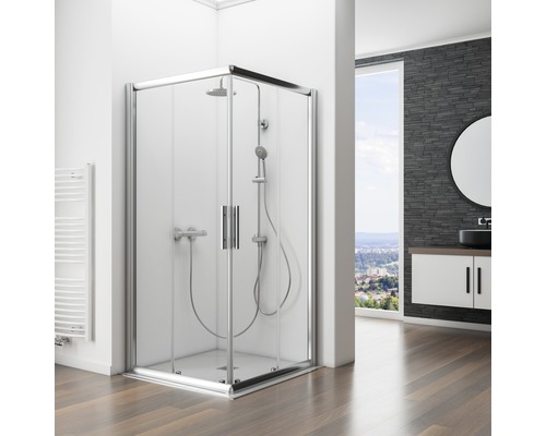 Cabină de duș pe colț cu uși din sticlă și set de duș într-o baie cu dulap de bază pentru lavoar și oglindă.