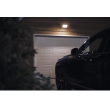 Scenă cu un garaj luminat de o plafonieră, cu o mașină în fața acestuia.