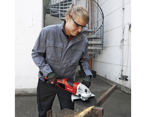 Bărbat tăind metal cu un polizor unghiular Einhell cu ochelari de protecție