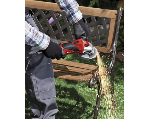 O persoană folosește un polizor unghiular Einhell pentru a lucra la o bancă de grădină. Sar scântei.