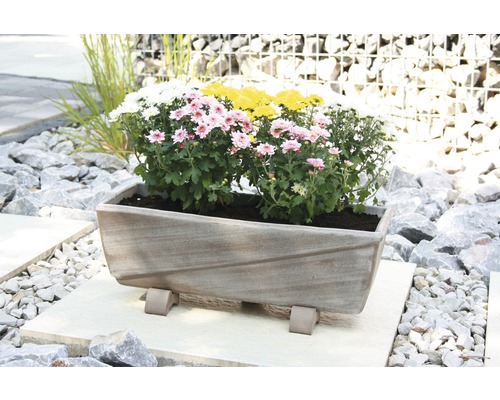 Jardinieră dreptunghiulară cu flori pe o podea de piatră