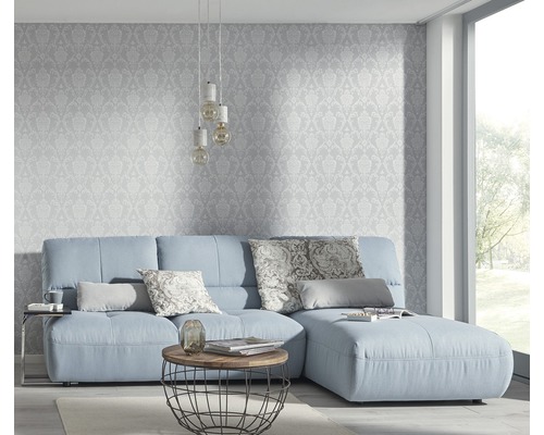 Living cu canapea albastru deschis, măsuță de cafea și tapet cu model
