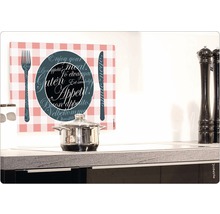 Scenă de bucătărie cu oală, râșnițe de piper și o placă de sticlă imprimată cu motive de tacâmuri și inscripția Poftă bună