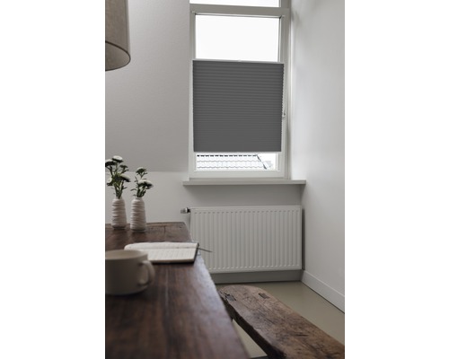 Fotografie de interior a unei camere cu un pliseu gri la fereastră, o masă de lemn și o bancă