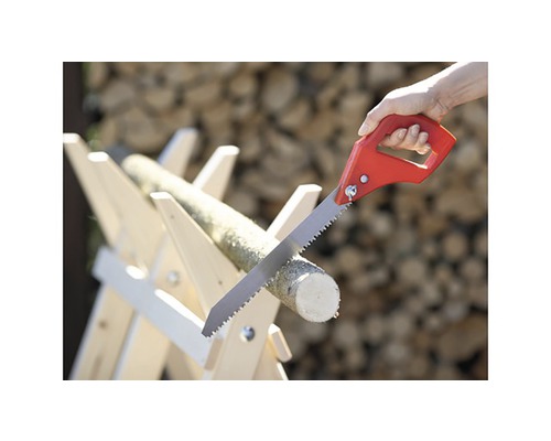 Fierăstrău manual tăind o bucată de lemn pe un capră de lemn