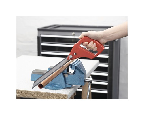 Fierăstrău manual taie țeava fixată într-o menghină