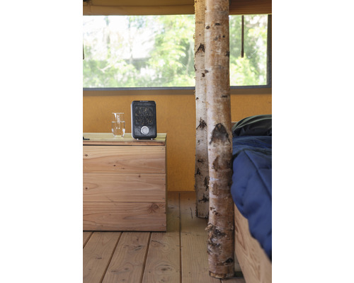 Interiorul unui cort cu podea din lemn, noptieră, încălzitor și pat