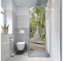 Baie modernă cu toaletă, fereastră și cabină de duș cu motiv de pod în junglă