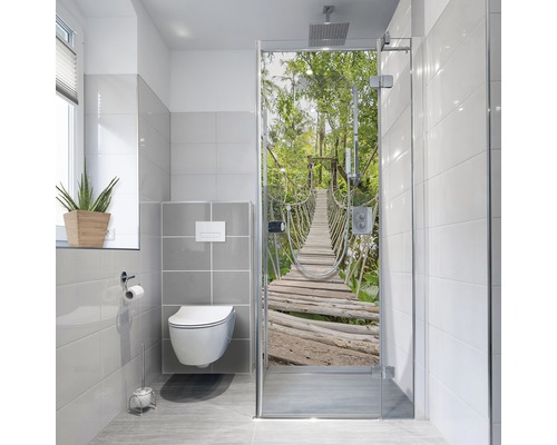 Baie modernă cu toaletă, fereastră și cabină de duș cu motiv de pod în junglă