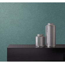 Prim-plan al unui perete cu tapet netesut și două vaze decorative pe o comodă