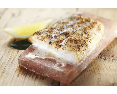 File de pește cu condimente pe o piatră de sare cu lămâie