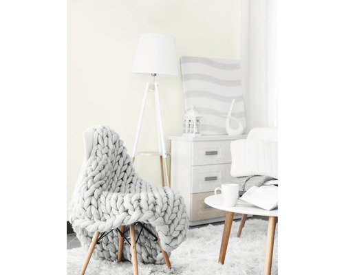 Scenă de sufragerie cu fotoliu, pătură tricotată, lampadar, măsuță laterală și comodă