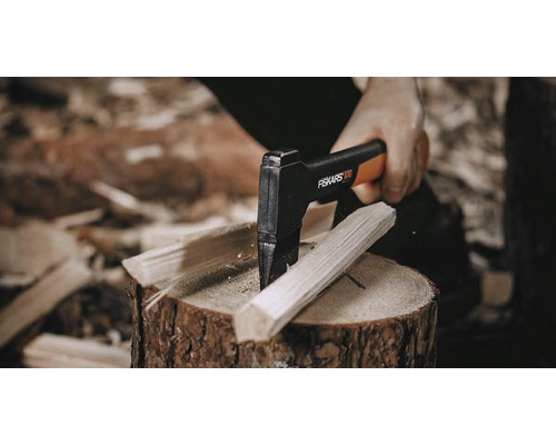 Tăierea lemnelor cu un topor de despicat Fiskars pe un butuc