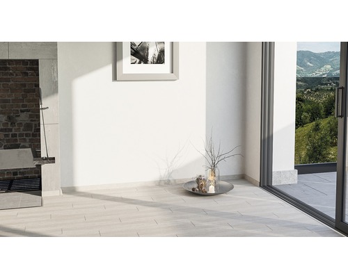 Interior cu podea cu gresie, grătar și ușă glisantă spre grădină