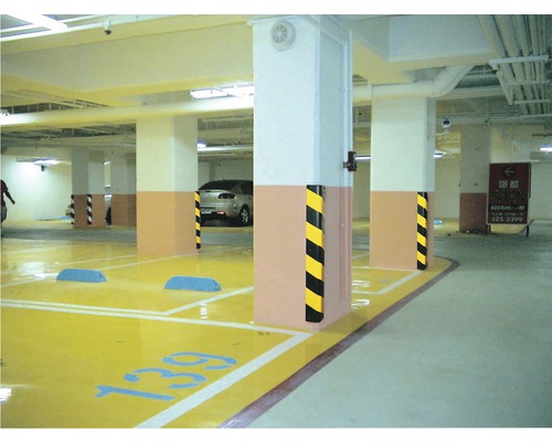Scenă dintr-o parcare subterană cu stâlpi de beton și locuri de parcare marcate cu galben