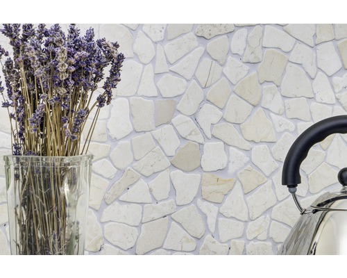 Perete decorativ cu plăci de mozaic din piatră naturală într-un interior, completat cu lavandă într-o vază de sticlă și un ceainic din oțel inoxidabil.