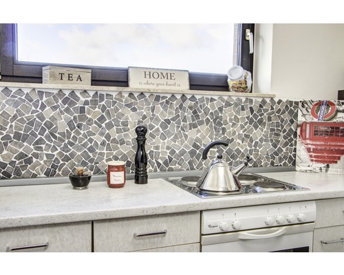 Scenă de bucătărie cu plăci de mozaic, aragaz și ustensile de bucătărie