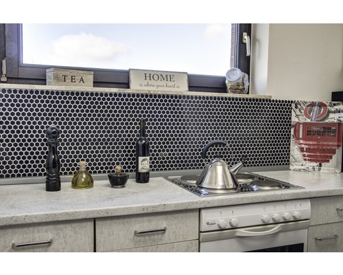 Scenă de bucătărie cu chiuvetă, aragaz, robinete și ustensile de bucătărie pe fundal de mozaic negru