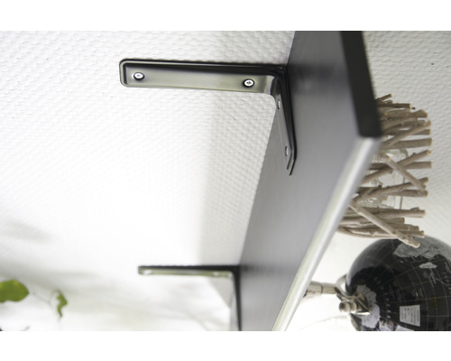 Raft negru de perete cu suporturi pe un perete alb