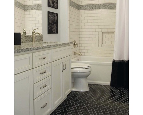 Baie cu lavoar alb, toaletă, cadă și gresie hexagonală