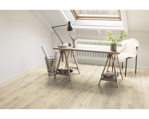 Cameră luminoasă cu birou pe podele din lemn sub o fereastră de mansardă.