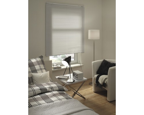 Dormitor luminos cu fereastră, jaluzea plisată, pat și fotoliu