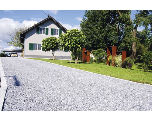 Alee cu pietriș în fața unei case cu grădină