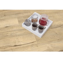 Podea deschisă la culoare din lemn cu tavă albă, ceainic, două cești și cutie de biscuiți