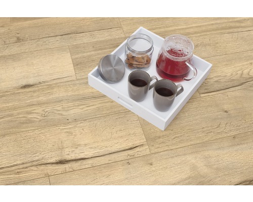 Podea deschisă la culoare din lemn cu tavă albă, ceainic, două cești și cutie de biscuiți