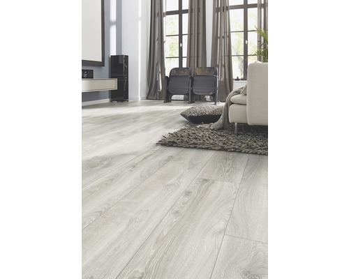 Cameră de zi luminoasă cu podea laminată cu aspect de lemn, canapea și covor