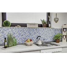 Scenă de bucătărie cu plăci de mozaic, decorațiuni și ustensile de gătit pe un blat de lucru.