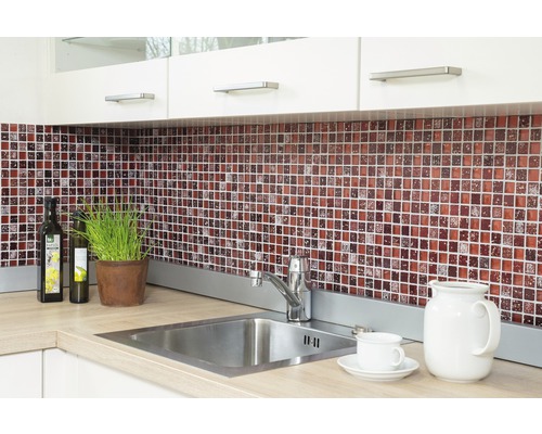 Scenă de bucătărie cu plăci de mozaic, chiuvetă și ustensile de bucătărie pe blat.