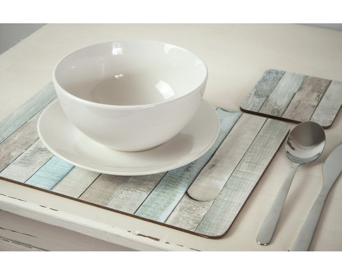 Masa aranjată cu bol alb, farfurie, tacâmuri și suporturi de pahare cu design de lemn