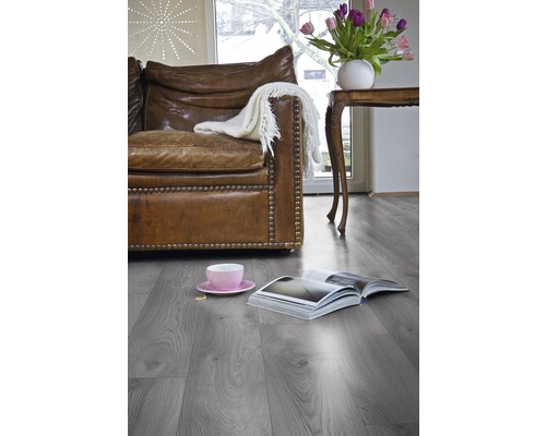 Living cu parchet laminat gri, canapea din piele și decorațiuni