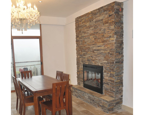 Sufragerie cu masă, scaune și șemineu cu decor din piatră