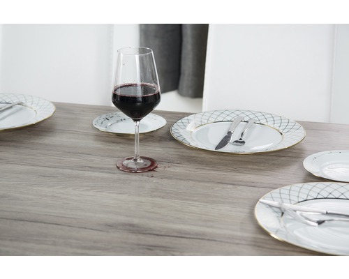 Masa aranjată cu pahar de vin, farfurii și tacâmuri