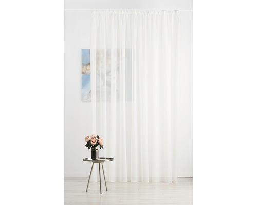 Perdea albă transparentă în fața unui perete cu o pictură și o masă cu flori