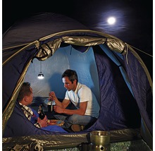 Doi oameni într-un cort cu lampă de camping și aragaz în camping.