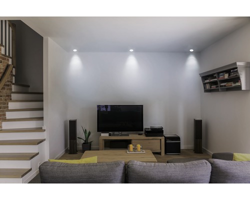 Living luminos cu scară, perete TV și canapea