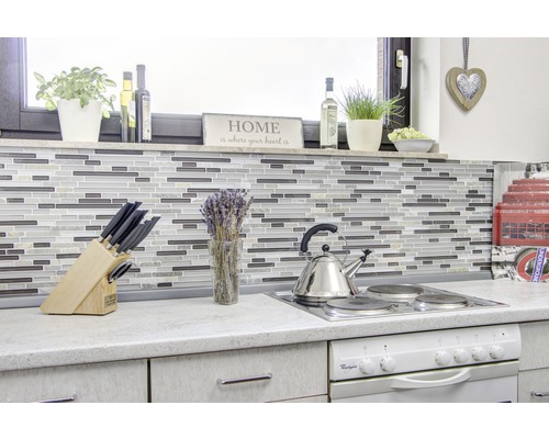 Scenă de bucătărie cu plăci de mozaic, plită, chiuvetă și diverse ustensile de bucătărie