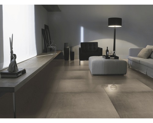 Living cu gresie, canapea, fotoliu și lampă de podea.